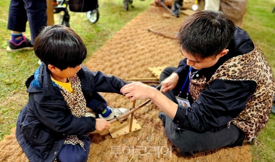 Splitting wood with a stone axe and lighting a Paleolithic fire / Photo - TourKorea