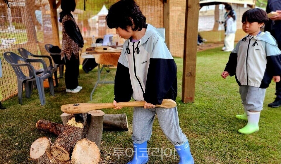 Splitting wood with a stone axe and lighting a Paleolithic fire / Photo - TourKorea